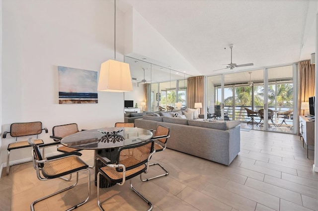 dining space with high vaulted ceiling and ceiling fan