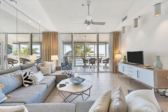 living room featuring ceiling fan, floor to ceiling windows, and a textured ceiling