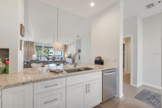 kitchen featuring sink, stainless steel dishwasher, kitchen peninsula, light stone countertops, and white cabinets