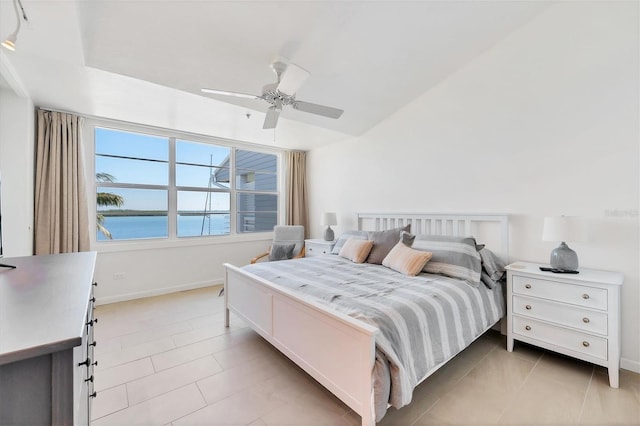 bedroom with a water view, ceiling fan, lofted ceiling, and light tile patterned floors