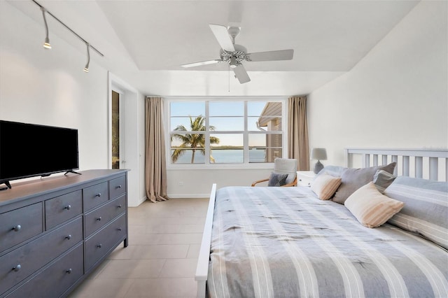 bedroom with a water view and ceiling fan