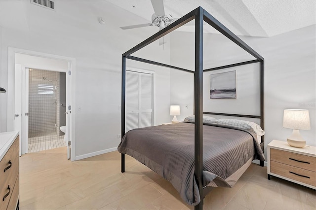 bedroom with ceiling fan, ensuite bath, and a closet