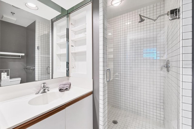 bathroom with vanity, toilet, and a shower with shower door