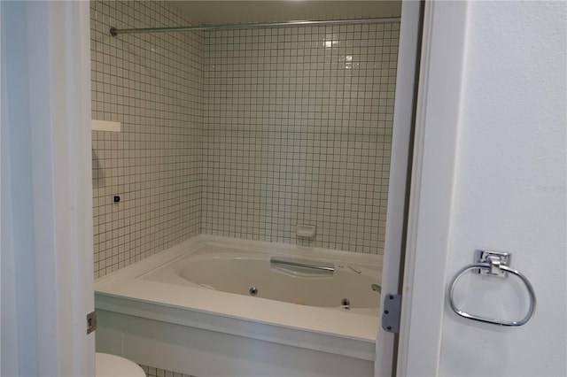 bathroom with toilet and tiled shower / bath combo