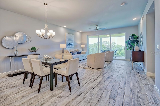 dining area with ceiling fan with notable chandelier and light hardwood / wood-style floors