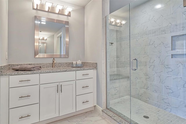 bathroom featuring a shower with door and vanity