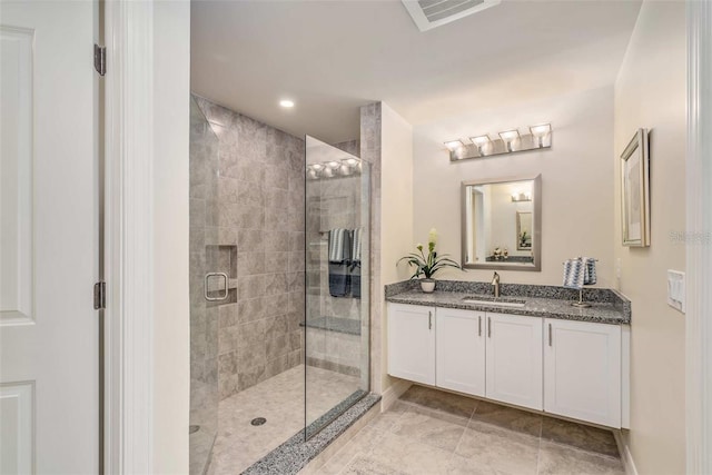 bathroom with vanity and a shower with door