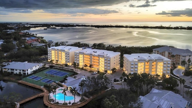 aerial view at dusk featuring a water view