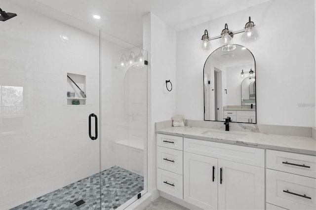 bathroom with a stall shower and vanity