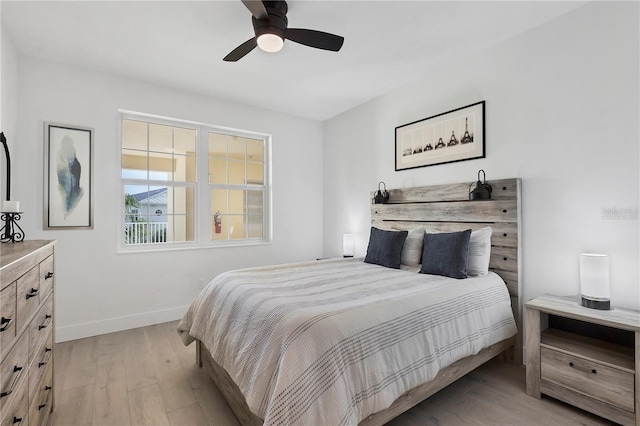 bedroom featuring baseboards, ceiling fan, and light wood finished floors