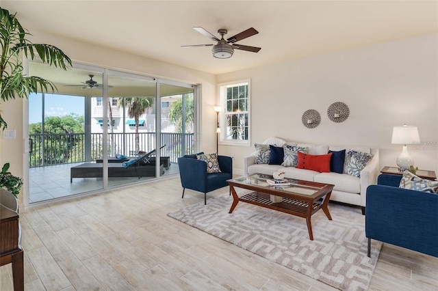 living room with ceiling fan and light hardwood / wood-style flooring