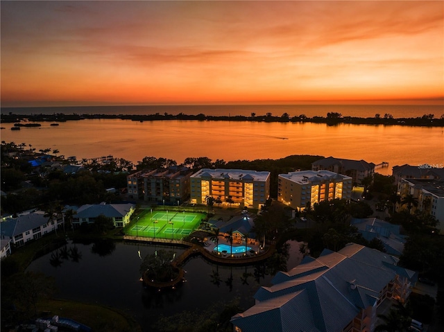 aerial view at dusk featuring a water view