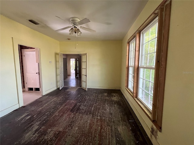 empty room featuring dark hardwood / wood-style floors, ceiling fan, and french doors