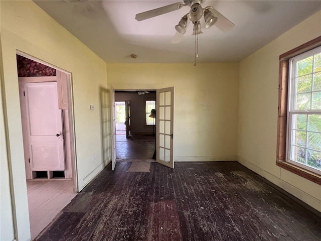 empty room featuring ceiling fan, french doors, and dark hardwood / wood-style floors