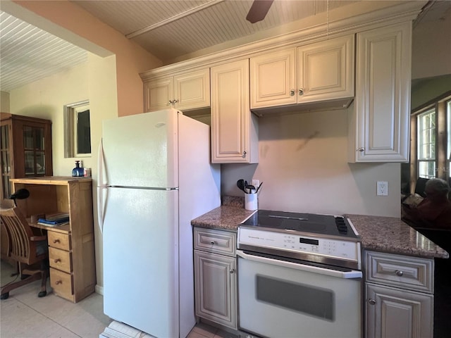 kitchen with ceiling fan, light tile patterned floors, dark stone counters, and white appliances