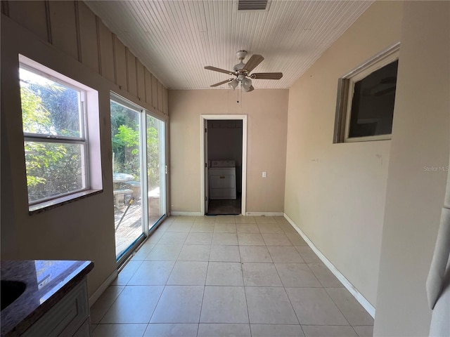 interior space with ceiling fan, light tile patterned flooring, washer / dryer, and wood ceiling