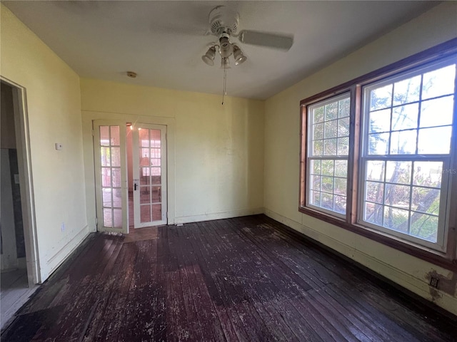 empty room featuring ceiling fan, dark hardwood / wood-style flooring, and french doors