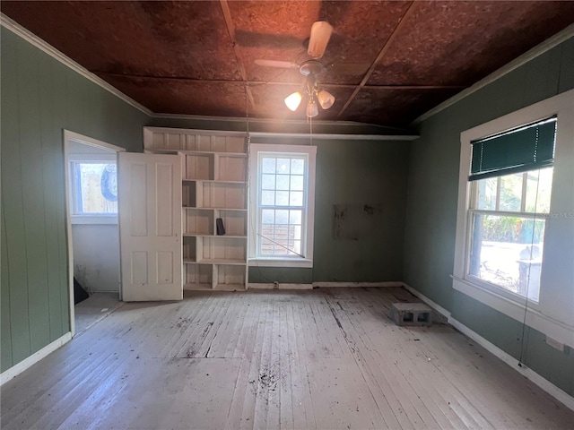 spare room featuring hardwood / wood-style floors, ceiling fan, and a healthy amount of sunlight