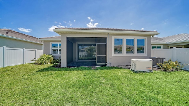 back of property featuring a sunroom, a lawn, and central AC