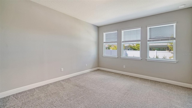 unfurnished room featuring a textured ceiling and carpet floors