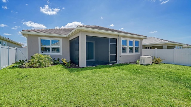 back of property featuring a lawn and a sunroom