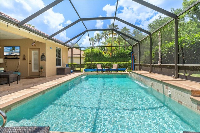 view of pool featuring pool water feature, a patio area, and a lanai