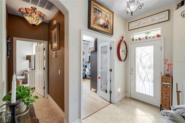 foyer entrance featuring light tile patterned floors and plenty of natural light