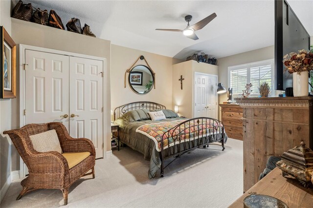 bedroom with two closets, carpet floors, and ceiling fan