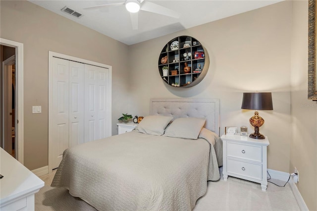 bedroom featuring a closet, light colored carpet, and ceiling fan