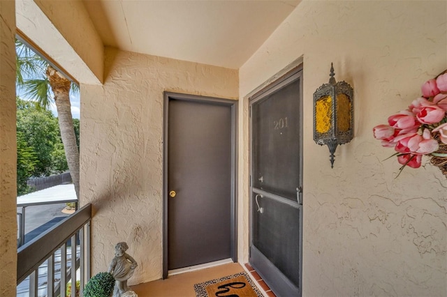 view of exterior entry with a balcony