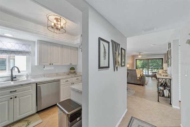 kitchen featuring light tile flooring, ceiling fan with notable chandelier, white cabinetry, sink, and stainless steel dishwasher