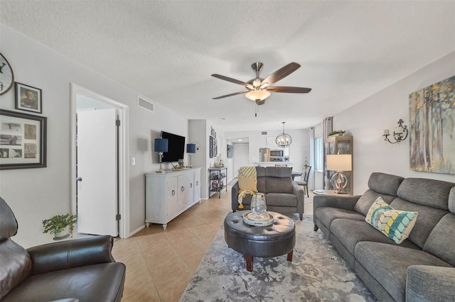 tiled living room featuring a textured ceiling and ceiling fan