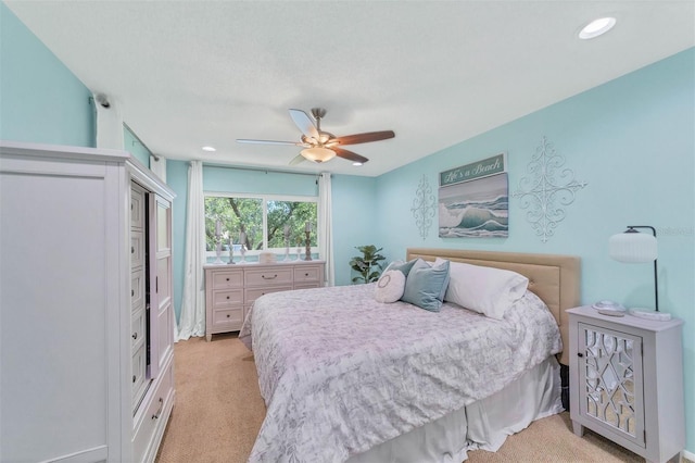 bedroom with light colored carpet, ceiling fan, and a closet