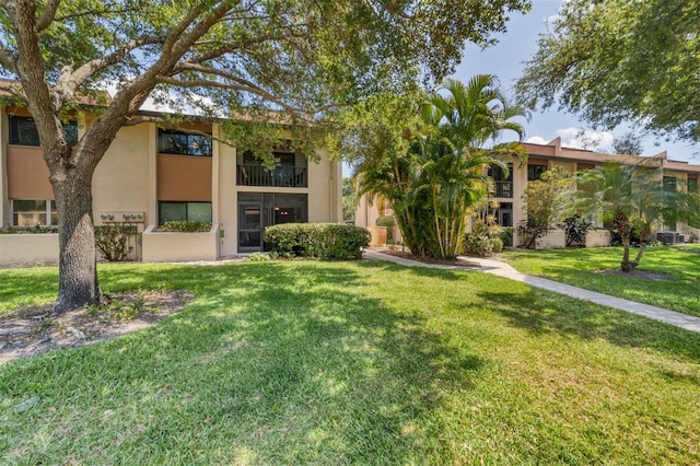 view of front of home with a front yard and a balcony