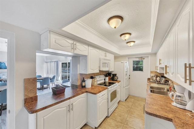 kitchen with white cabinetry, sink, white appliances, and a raised ceiling