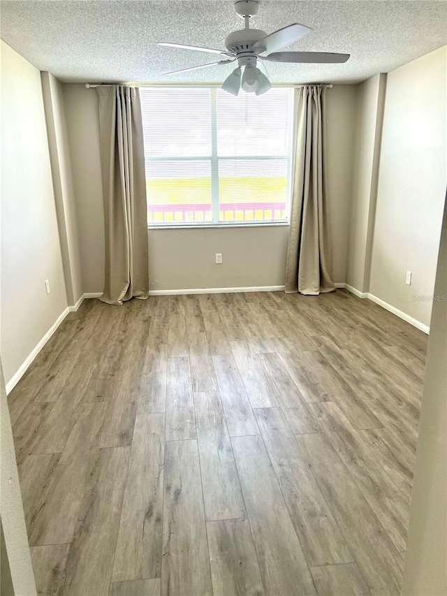 spare room with hardwood / wood-style floors, a textured ceiling, and ceiling fan