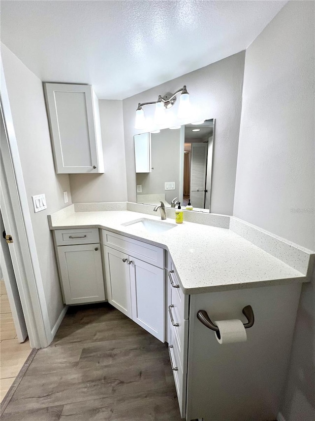 kitchen with kitchen peninsula, white cabinets, dark wood-type flooring, and sink