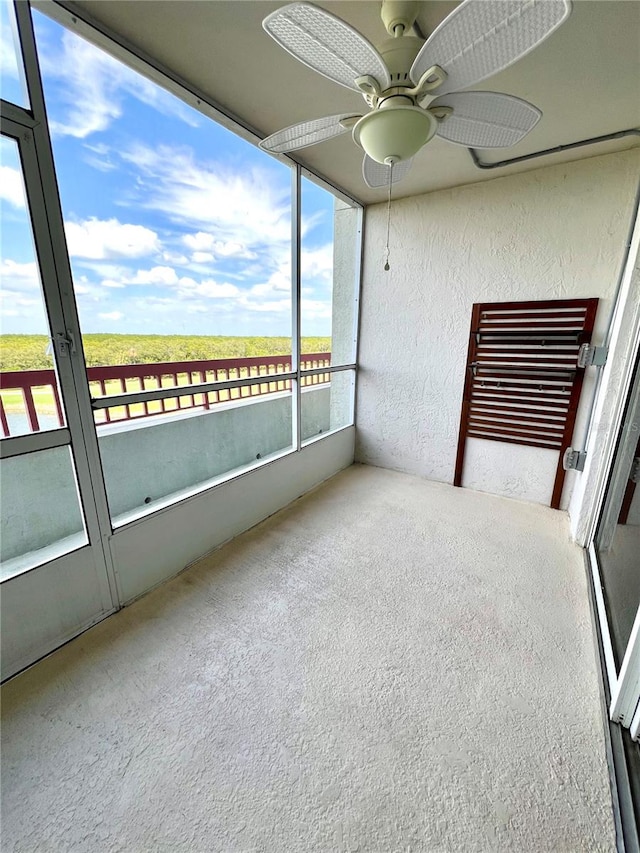 unfurnished sunroom featuring ceiling fan