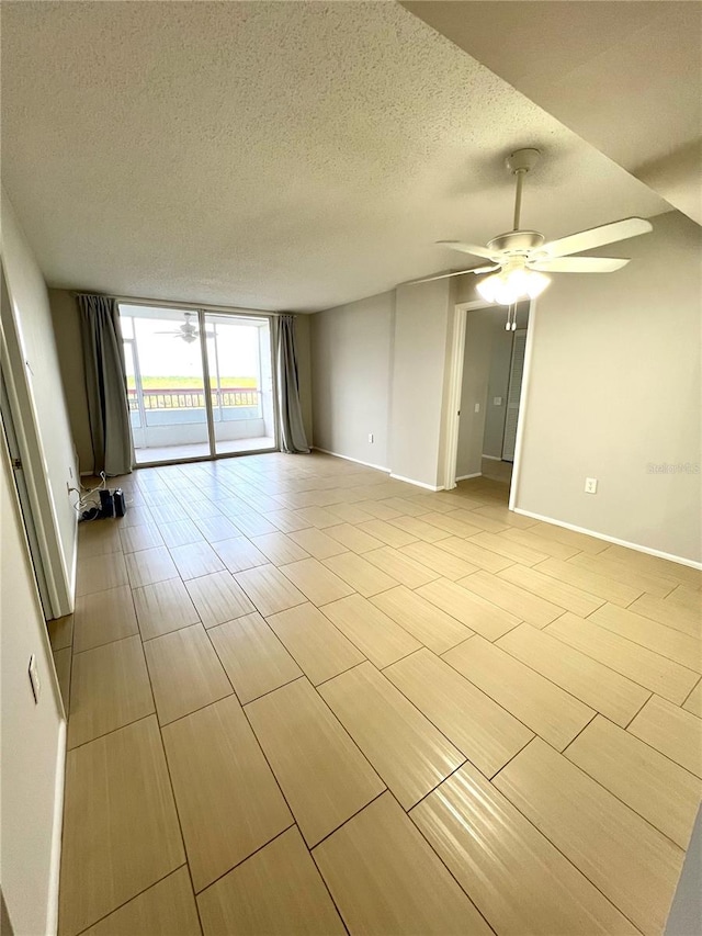 empty room with ceiling fan and a textured ceiling