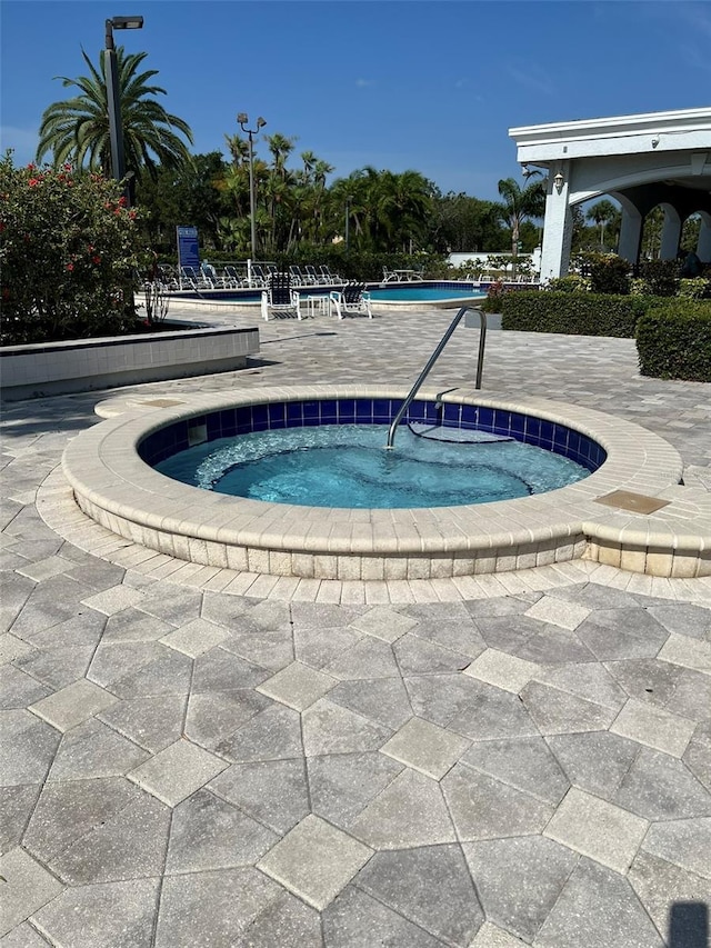 view of pool featuring a community hot tub and a patio