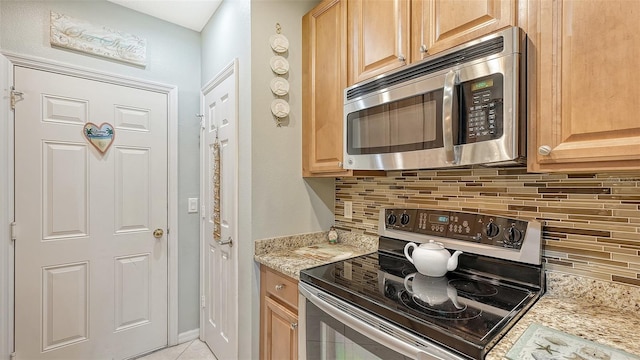 kitchen featuring backsplash, electric range, and light stone counters