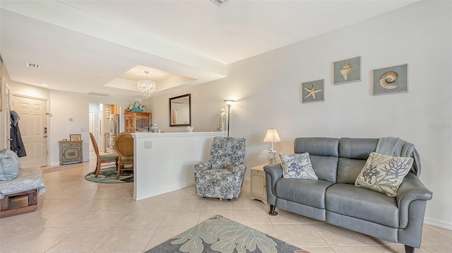 living room with light tile flooring and a raised ceiling