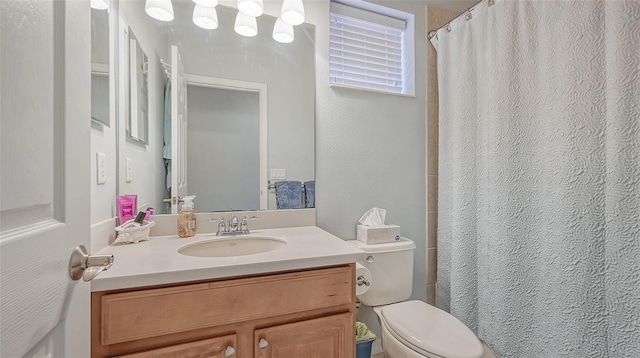 bathroom featuring vanity with extensive cabinet space and toilet