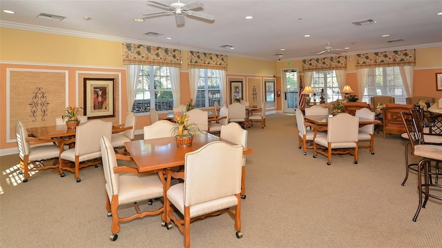 dining room with ornamental molding, light colored carpet, and ceiling fan