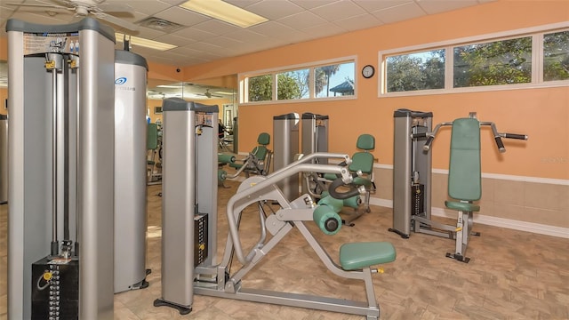 gym featuring a paneled ceiling and ceiling fan