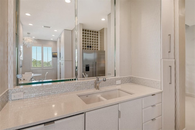 bathroom with vanity and tasteful backsplash