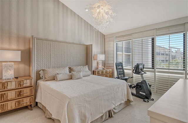 carpeted bedroom featuring lofted ceiling and a chandelier