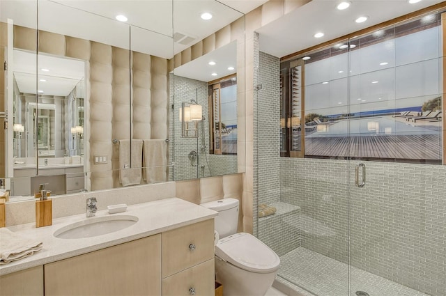 bathroom with walk in shower, oversized vanity, tile walls, and toilet