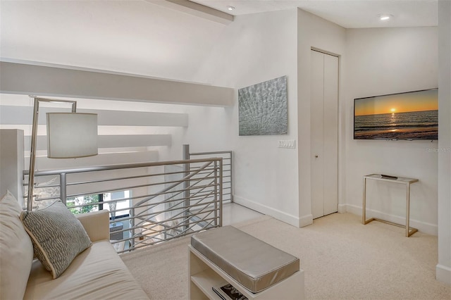 living room with light colored carpet and vaulted ceiling with beams