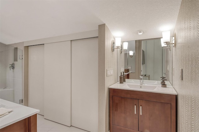 bathroom with tile floors, vanity, and a textured ceiling